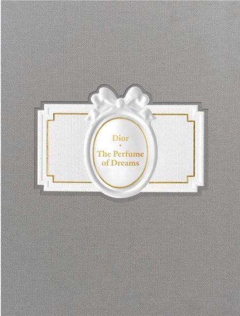 Text: "Dior The Perfume of Dreams." Weißes Etikett mit Schleifenmotiv auf grauem Hintergrund.