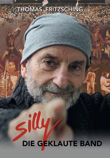 "THOMAS FRITZSCHING" oben, "silly DIE GEKLAUTE BAND" unten. Ein Mann mit grauer Mütze zeigt in die Kamera; im Hintergrund ein Konzert.