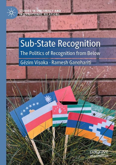 „Sub-State Recognition“ von Gëzim Visoka und Ramesh Ganohariti. Kleine Flaggen in Pflanzen vor einer Ziegelwand.