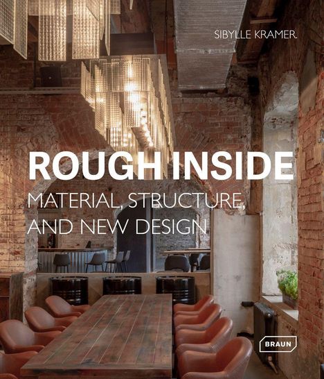 "Rough Inside: Material, Structure, and New Design". Rustikaler Raum mit Ziegelwänden, Holztisch, Ledersesseln und moderner Beleuchtung.