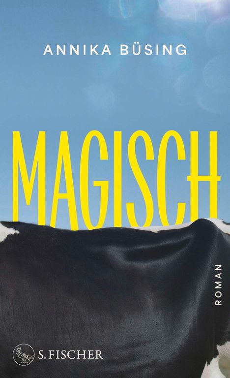 "ANNIKA BÜSING, MAGISCH, ROMAN" in gelber Schrift. Eine schwarz-weiße Kuh vor blauem Himmel. "S. Fischer" Logo unten.