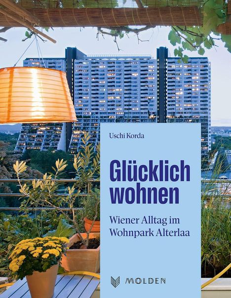 Text: "Glücklich wohnen. Wiener Alltag im Wohnpark Alterlaa." Eine Terrasse mit Pflanzen, Lampe und Hochhaus im Hintergrund.