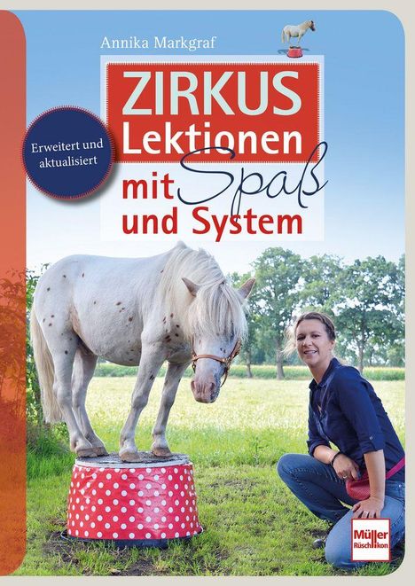 "Zirkus Lektionen mit Spaß und System. Erweitert und aktualisiert. Annika Markgraf." Ein Pony steht auf einem gepunkteten Podest, daneben eine lächelnde Frau.