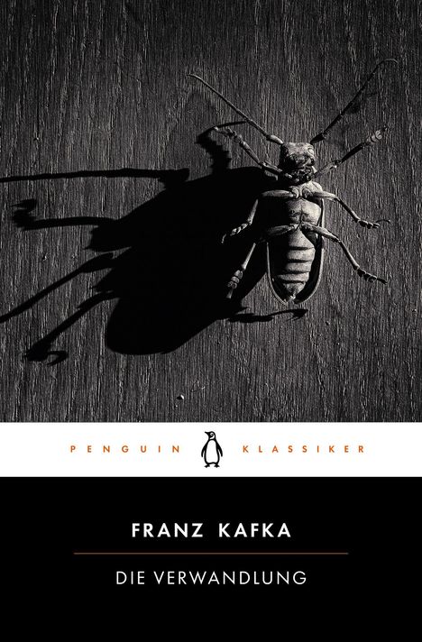 "Franz Kafka: Die Verwandlung." Ein Insekt mit langen Beinen und Schatten auf dunklem Holz. Penguin Klassik Logo darunter.