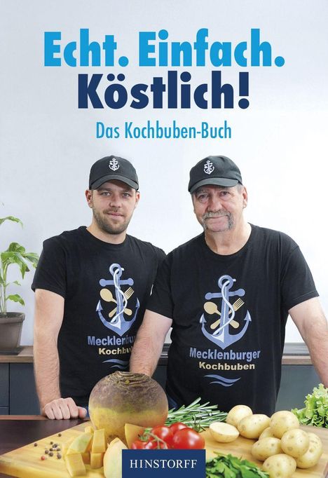 "Echt. Einfach. Köstlich! Das Kochbuben-Buch." Zwei Männer in schwarzen T-Shirts stehen vor Zutaten in einer Küche.