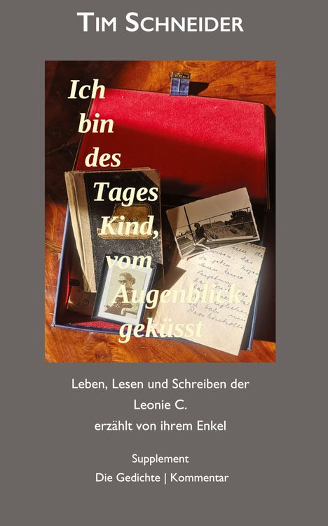 "Ich bin des Tages Kind, vom Augenblick geküsst" über einem Fotoalbum mit Schriftstücken und alten Fotos.
