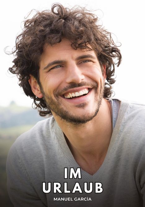 "IM URLAUB MANUEL GARCÍA." Ein lächelnder Mann mit lockigem Haar und Bart, trägt einen Pullover vor unscharfem Hintergrund.