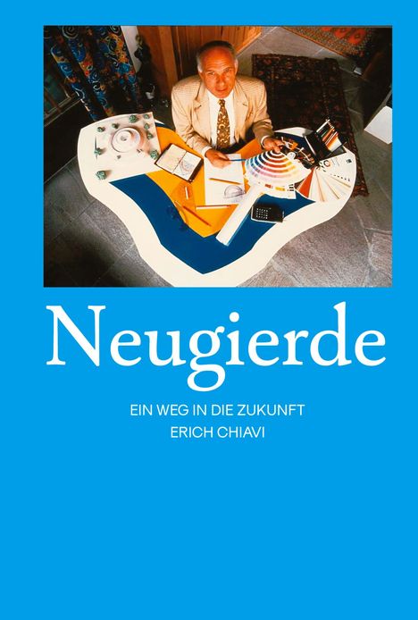 "Neugierde" in groß, darunter "Ein Weg in die Zukunft Erich Chiavi". Ein Mann am bunten Schreibtisch mit Notizen und Farbpaletten.