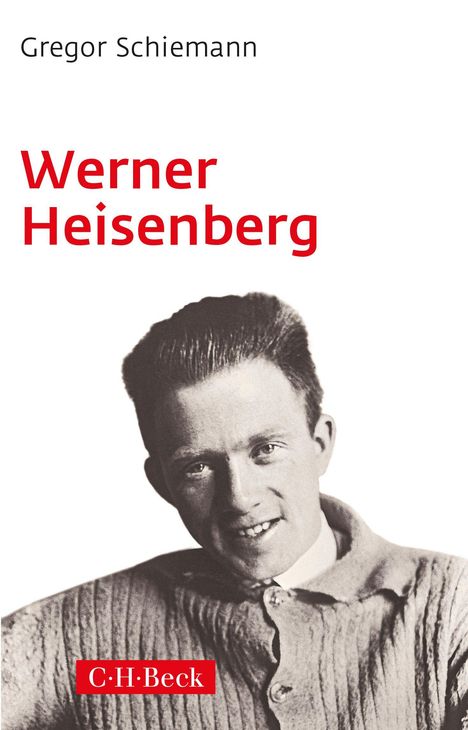 "Gregor Schiemann, Werner Heisenberg, C.H.Beck." Ein Mann lächelt freundlich in schwarz-weiß, bekleidet mit einem Strickpullover.