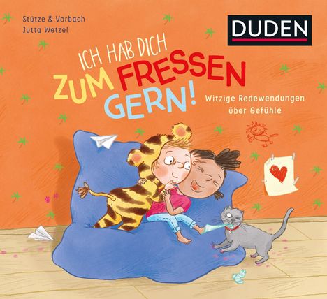 "Ich hab dich zum Fressen gern! Witzige Redewendungen über Gefühle." Zwei Kinder kuscheln auf blauem Kissen, Katze spielt.