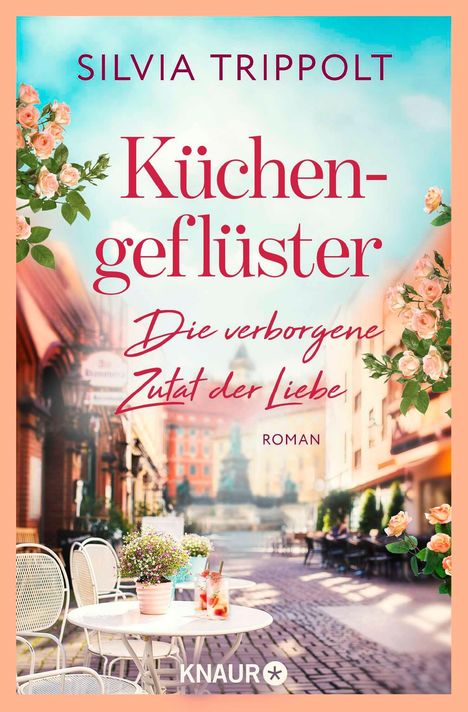 „Silvia Trippolt - Küchengeflüster: Die verborgene Zutat der Liebe“. Romantische Straßenszene mit Café-Tisch.