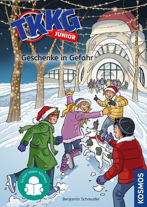 "Geschenke in Gefahr" und "Sicher lesen können". Kinder spielen im Schnee vor einem festlich beleuchteten Gebäude.