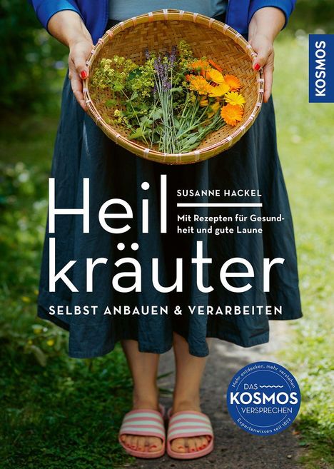 Titel: Heilkräuter. Autor: Susanne Hackel. Eine Person hält einen Korb mit verschiedenen Kräutern und Blumen.