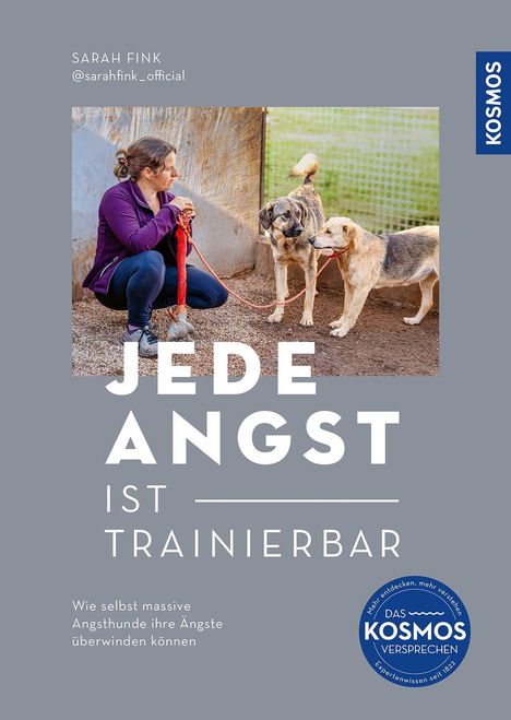 Titel: "JEDE ANGST IST TRAINIERBAR". Frau kniet, hält zwei angeleinte Hunde. Logo rechts.