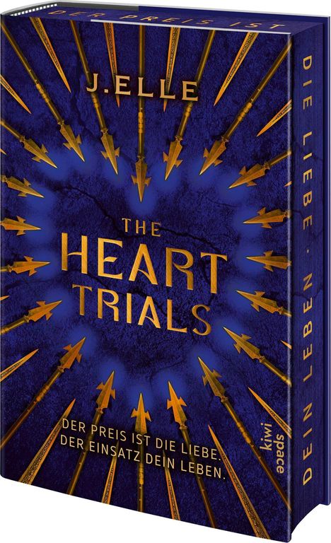 Buchtitel „The Heart Trials“ von J. Elle, Pfeile zeigen auf goldene Schrift auf blauem Hintergrund.