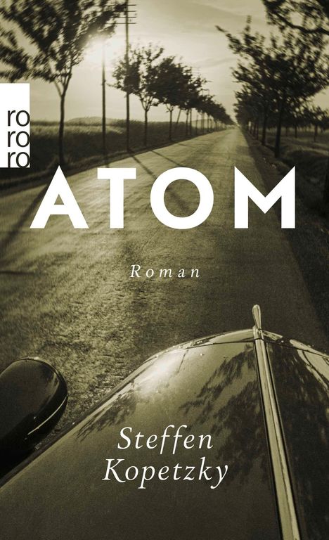 Text: "ATOM" und "Roman", "Steffen Kopetzky". Ein Auto fährt auf einer von Bäumen gesäumten Straße. Logo: "rororo".