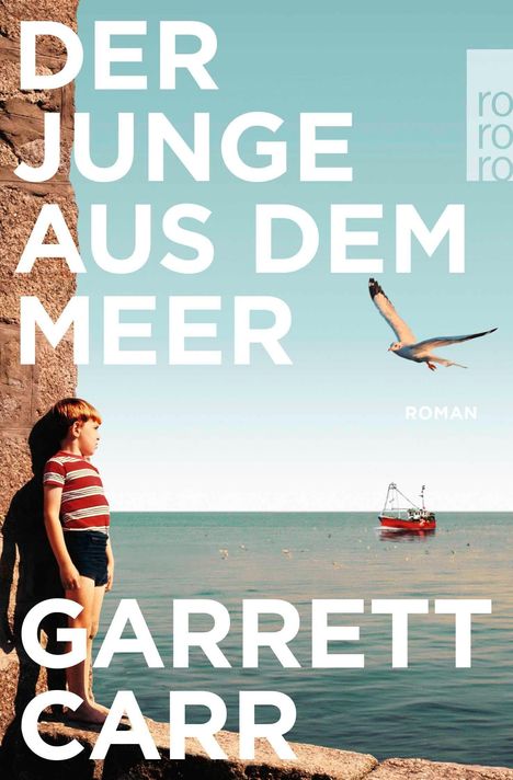 "DER JUNGE AUS DEM MEER", "GARRETT CARR", "ROMAN". Ein Junge steht an einer Felswand, nahe am Meer, eine Möwe fliegt.