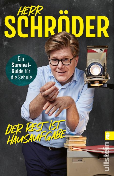 "HERR SCHRÖDER", "Ein Survival-Guide für die Schule", "DER REST IST HAUSAUFGABE". Ein Mann mit Brille und Overhead-Projektor.
