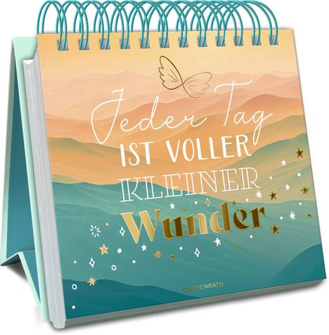 "Jeder Tag ist voller kleiner Wunder." Aufstellbuch mit buntem Hintergrund und Spirale.