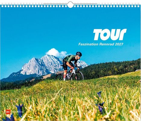 "TOUR Faszination Rennrad 2027". Ein Radfahrer auf einer Wiese, im Hintergrund Berge unter blauem Himmel.