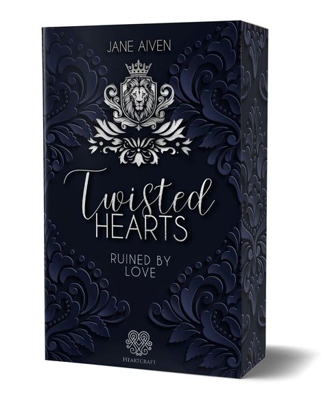 „Twisted Hearts“ steht in eleganten Buchstaben, darunter „Ruined by Love“. Oben ein Löwenwappen, florale Muster zieren den Hintergrund.