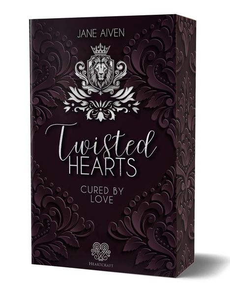 "Twisted Hearts" von Jane Aiven. "Cured by Love." Verzierungen und ein Löwenemblem auf dunklem Hintergrund.