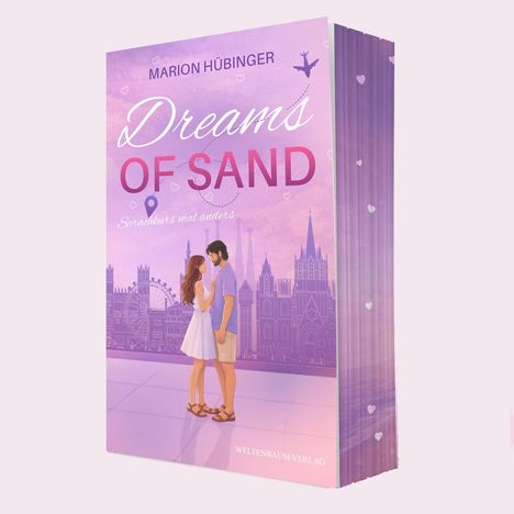 Text: "Dreams of Sand", "Sprachkurs mal anders", "Marion Hübinger", "Weltenbaum Verlag". Illustration: Paar vor Stadtsilhouette.