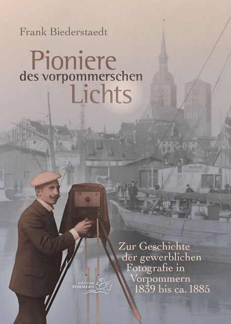 "Pioniere des vorpommerschen Lichts" von Frank Biederstaedt. Ein Fotograf mit alter Kamera vor historischer Hafenkulisse.