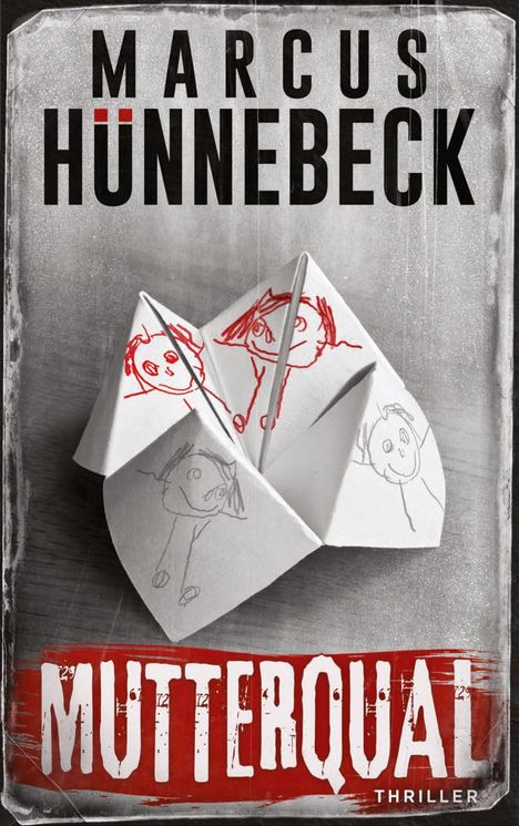 "Marcus Hünnebeck MUTTERQUAL Thriller." Ein Origami-Faltspiel mit Kinderzeichnungen auf einem Tisch.
