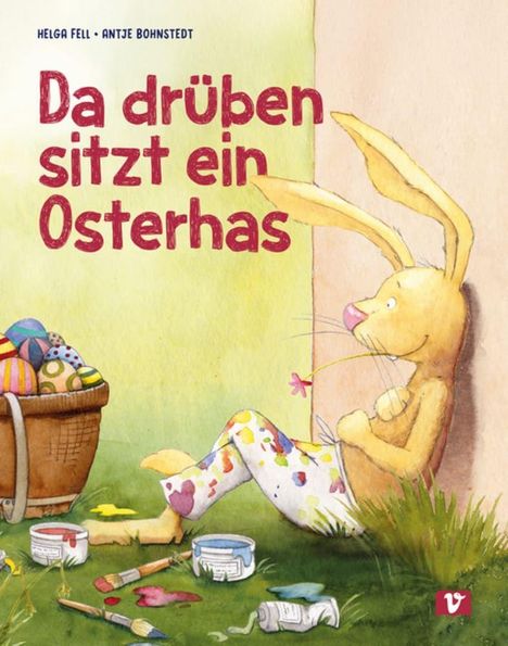 Titel: "Da drüben sitzt ein Osterhas". Ein Hase lehnt an einer Wand, trägt bemalte Hosen, neben ihm bunte Eier und Malutensilien.