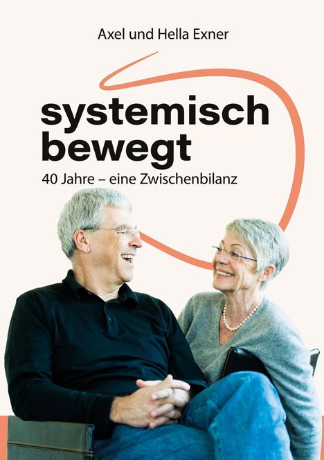 „Axel und Hella Exner: systemisch bewegt, 40 Jahre – eine Zwischenbilanz.“ Ein lachendes älteres Paar sitzt eng zusammen.