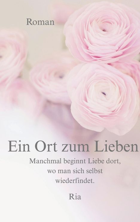 „Roman. Ein Ort zum Lieben. Manchmal beginnt Liebe dort, wo man sich selbst wiederfindet. Ria.“ Zarte rosa Blumen im Hintergrund.