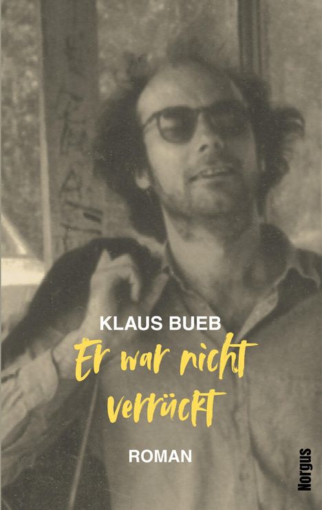 Text in der Mitte: "KLAUS BUEB Er war nicht verrückt ROMAN". Schwarz-weißes Foto eines Mannes mit Sonnenbrille.
