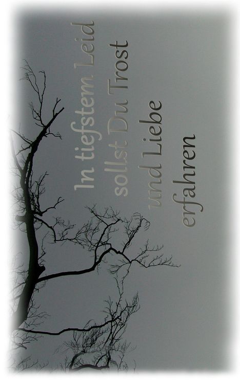 "In tiefstem Leid sollst Du Trost und Liebe erfahren." Silhouette eines kahlen Baumes vor grauem Hintergrund.