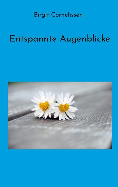 „Birgit Cornelissen, Entspannte Augenblicke.“ Zwei Gänseblümchen liegen auf einer Holzoberfläche.