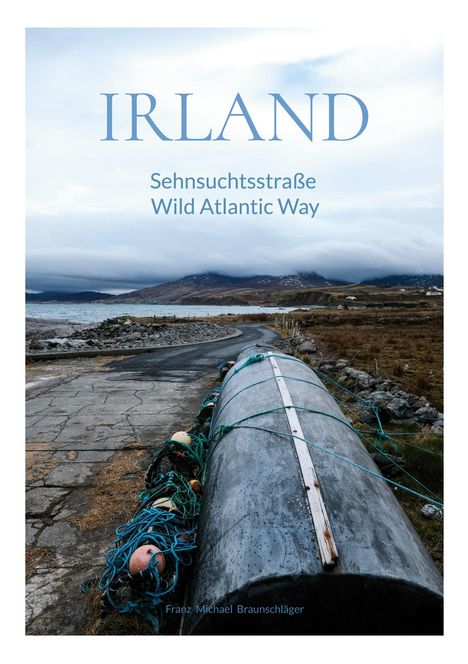 **IRLAND**  
Sehnsuchtsstraße  
Wild Atlantic Way  
Ein langer, schmaler Weg an der Küste mit einem umgedrehten Boot und Netzen.
