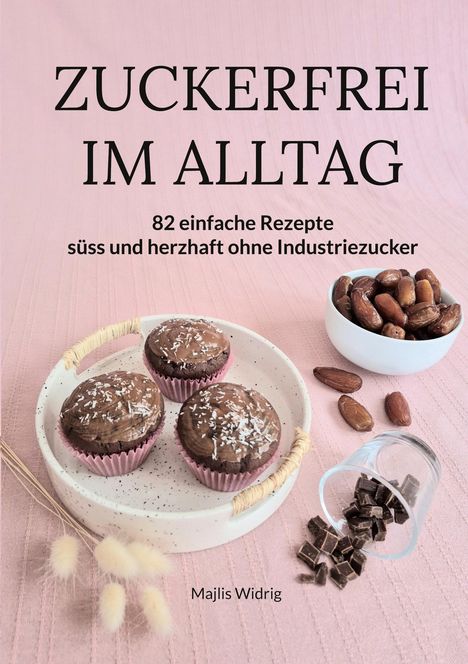 ZUCKERFREI IM ALLTAG. 82 Rezepte ohne Industriezucker. Drei Schokomuffins, Datteln und Schokostücke auf rosa Stoff.