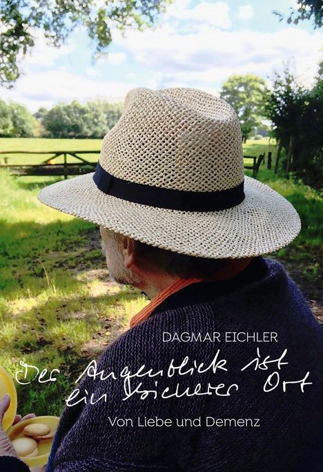 "Der Augenblick ist ein sicherer Ort. Von Liebe und Demenz. DAGMAR EICHLER."   
Ein Mann mit Strohhut sitzt im Grünen.