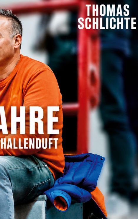 „THOMAS SCHLICHTE“, darunter „JAHRE HALLENDUFT“. Ein Mann in orangefarbenem Pullover sitzt, blaue Jacke liegt daneben.