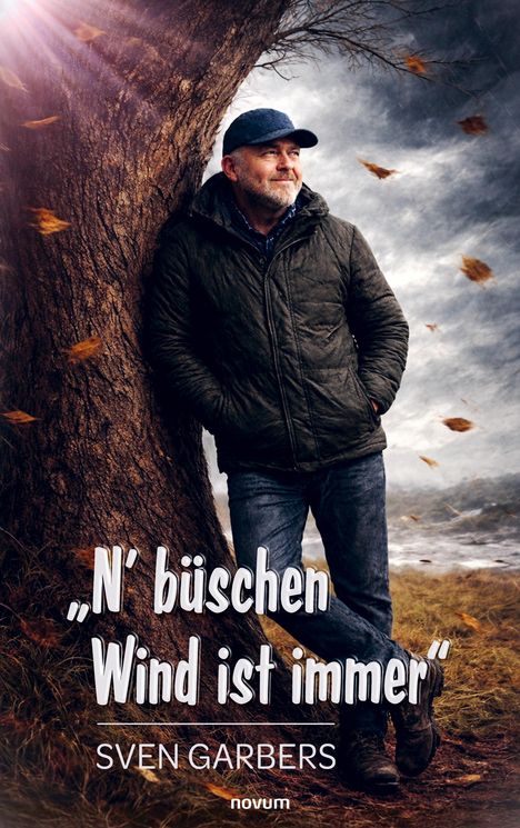 Titel: „N’ büschen Wind ist immer“. Autor: Sven Garbers. Ein Mann lehnt an einem Baum im windigen Herbst.