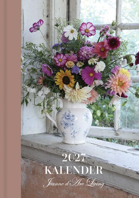 2027 KALENDER, Jeanne d’Arc Living. 
Ein Blumenstrauß mit bunten Blüten in einer Vase auf einer Fensterbank.