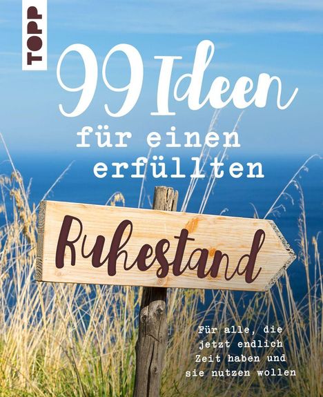 „99 Ideen für einen erfüllten Ruhestand. Für alle, die jetzt endlich Zeit haben.“ Holzschild vor Meer und Gräsern.