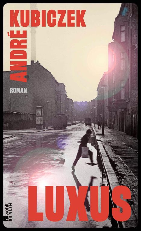 „André Kubiczek, Luxus“. Straße mit Schatten und Person in Bewegung. Dezente Farben, nostalgische Atmosphäre.