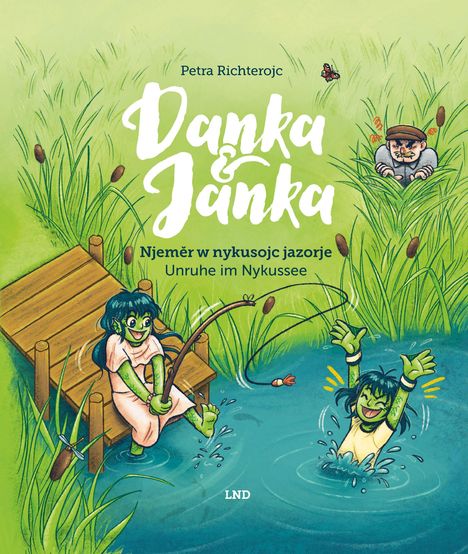 „Danka & Janka“, „Unruhe im Nykussee“. Zwei grüne Figuren; eine angelt, eine schwimmt. Ein Mann versteckt sich im Schilf.