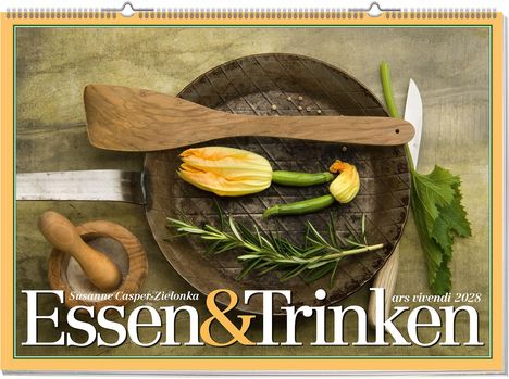 "Essen & Trinken" steht groß im Vordergrund. Ein Holzlöffel, Zucchiniblüten und Gewürze auf einer Pfanne arrangiert.