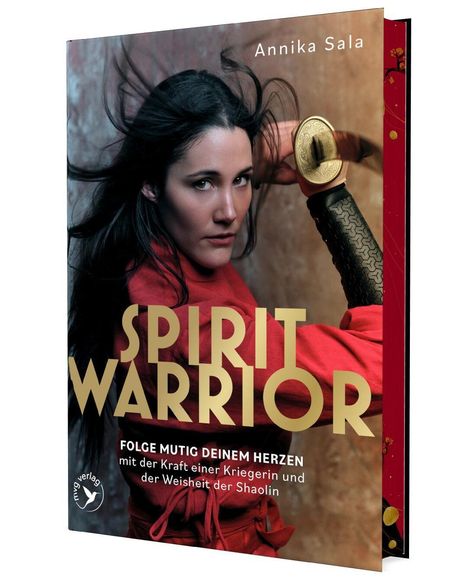 "SPIRIT WARRIOR: Folge mutig deinem Herzen" in Gold, Frau in rotem Gewand mit Schwert, entschlossener Blick.