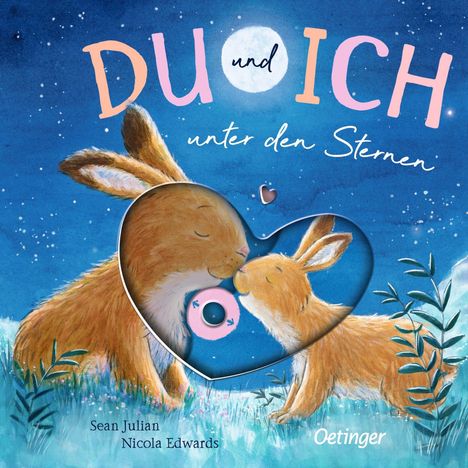„DU und ICH unter den Sternen“. Zwei Hasen kuscheln auf einer Wiese unter einem Sternenhimmel.
