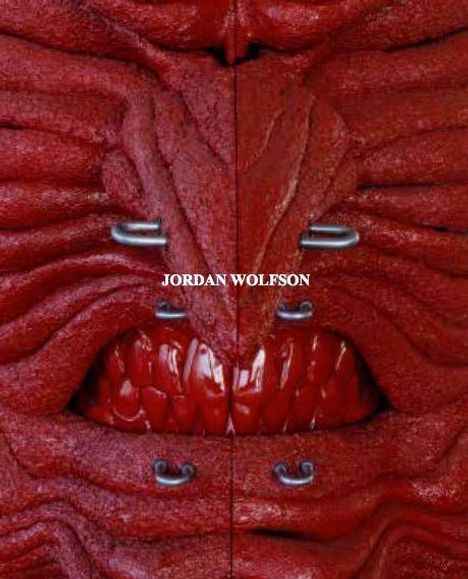 Text "JORDAN WOLFSON" zentral. Auffällige rote, fleischige Struktur mit metallischen Details, wirkt organisch und texturiert.
