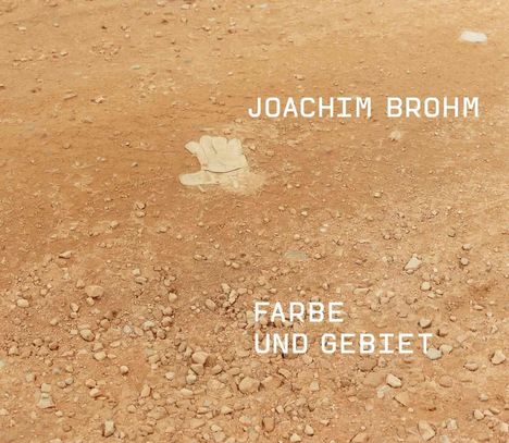 Texte: Joachim Brohm, FARBE UND GEBIET. Ein staubiger, erdiger Untergrund mit kleinen Steinen und einem weißen Fleck.