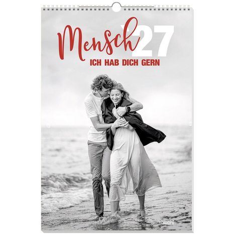 „Mensch 27, ich hab dich gern.“ Ein Paar umarmt sich am Strand und läuft lächelnd durchs flache Wasser.